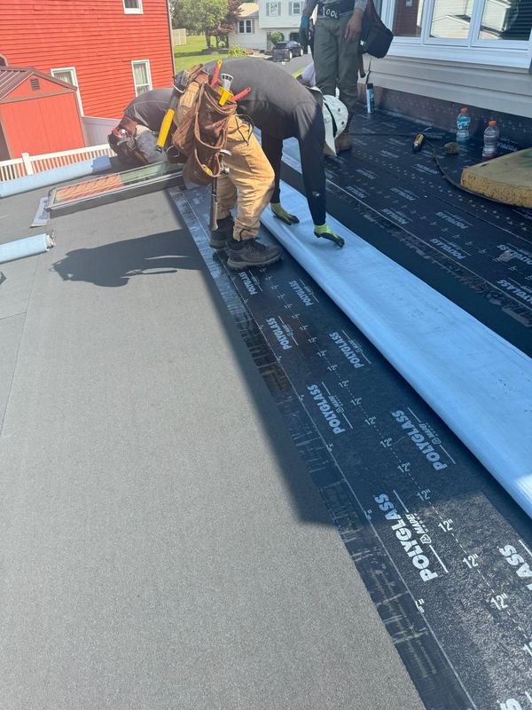 Our crew installing roofing membrane
