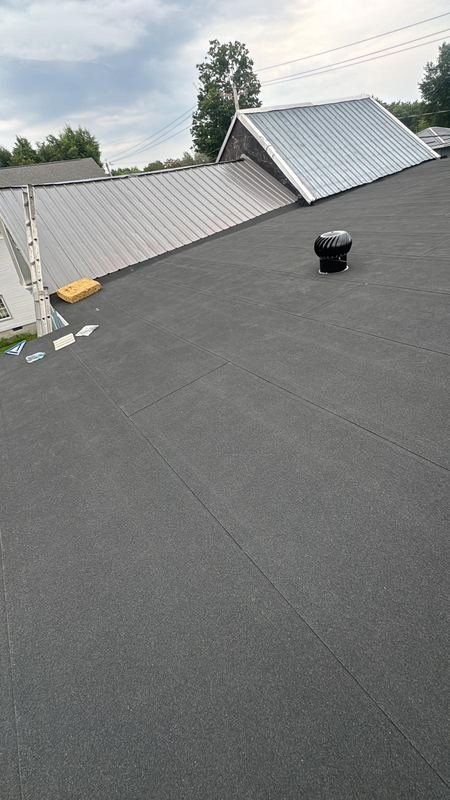 Low-slope roof next to a metal roof