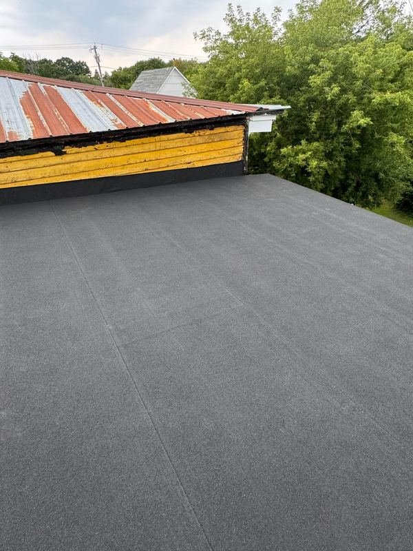 Flat roof next to an older metal roof